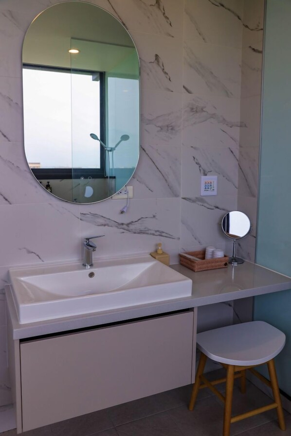 A bathroom with a white sink, a mirror, and a wooden stool. - Quhua Sweety B&B (Dongshan)