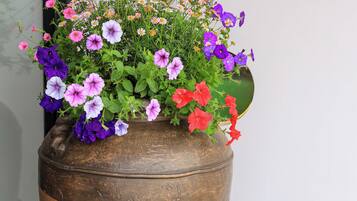 Una maceta de madera grande con una variedad de flores coloridas y follaje verde.
