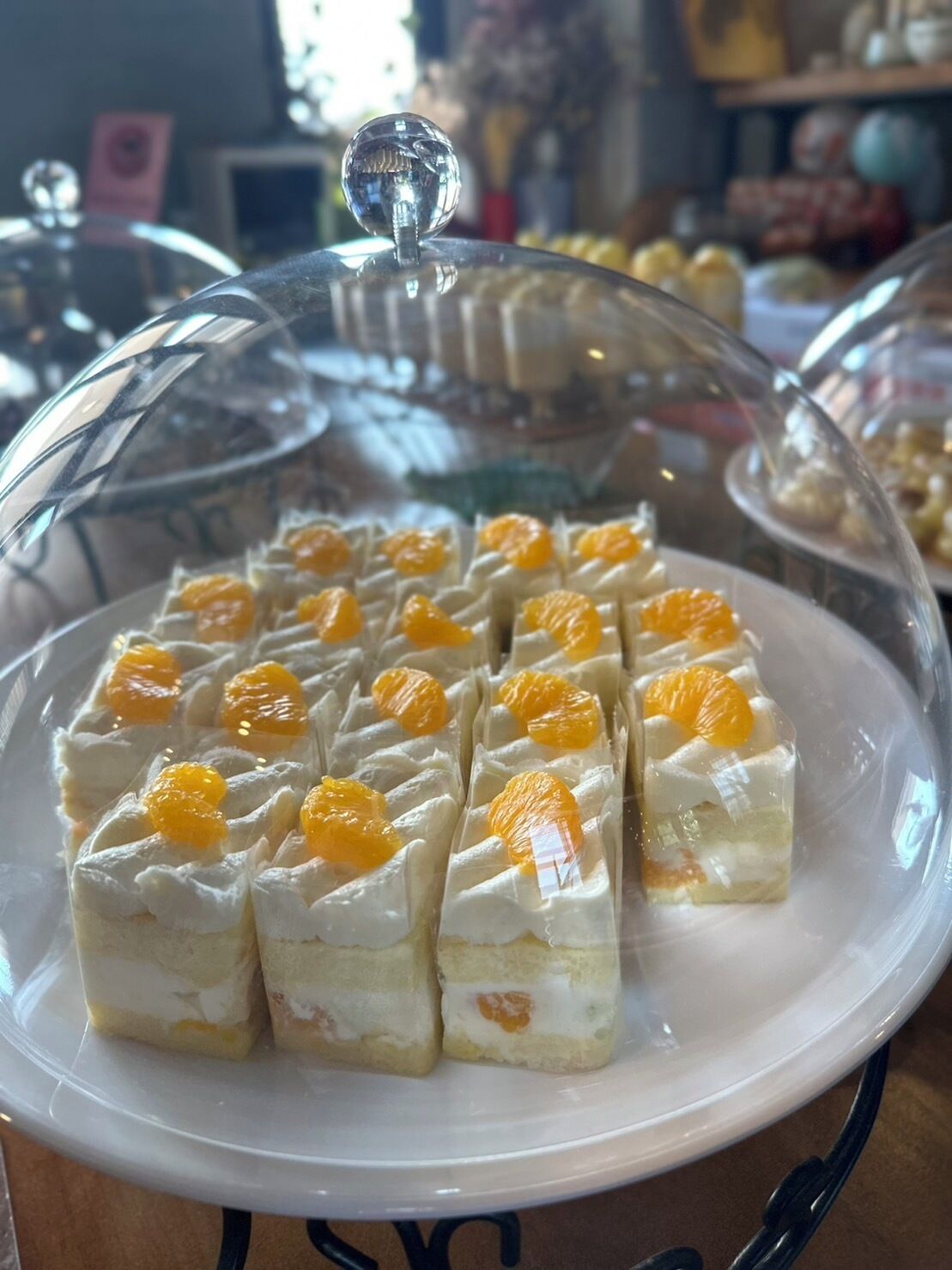 Un présentoir à desserts recouvert d’un couvercle en verre en forme de dôme.