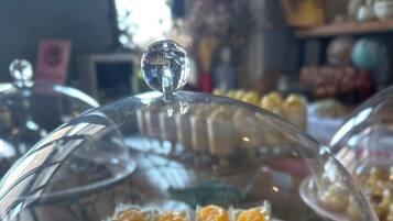 Un présentoir à desserts recouvert d’un couvercle en verre en forme de dôme.