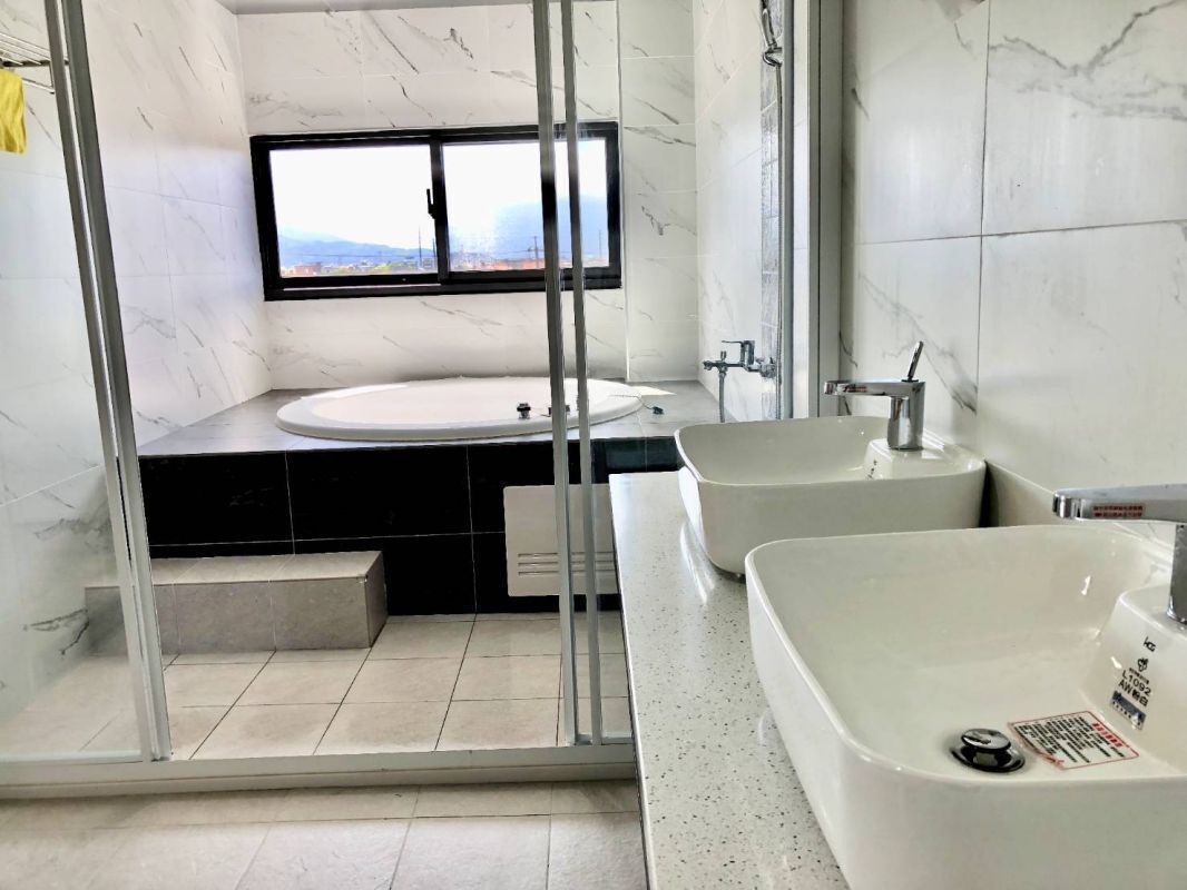Un baño moderno con un lavamanos grande, una bañera y una zona de ducha.