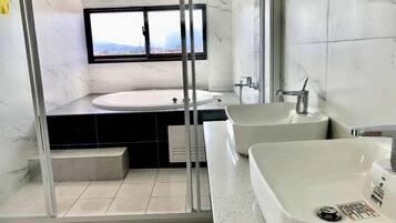 Un baño moderno con un lavamanos grande, una bañera y una zona de ducha.