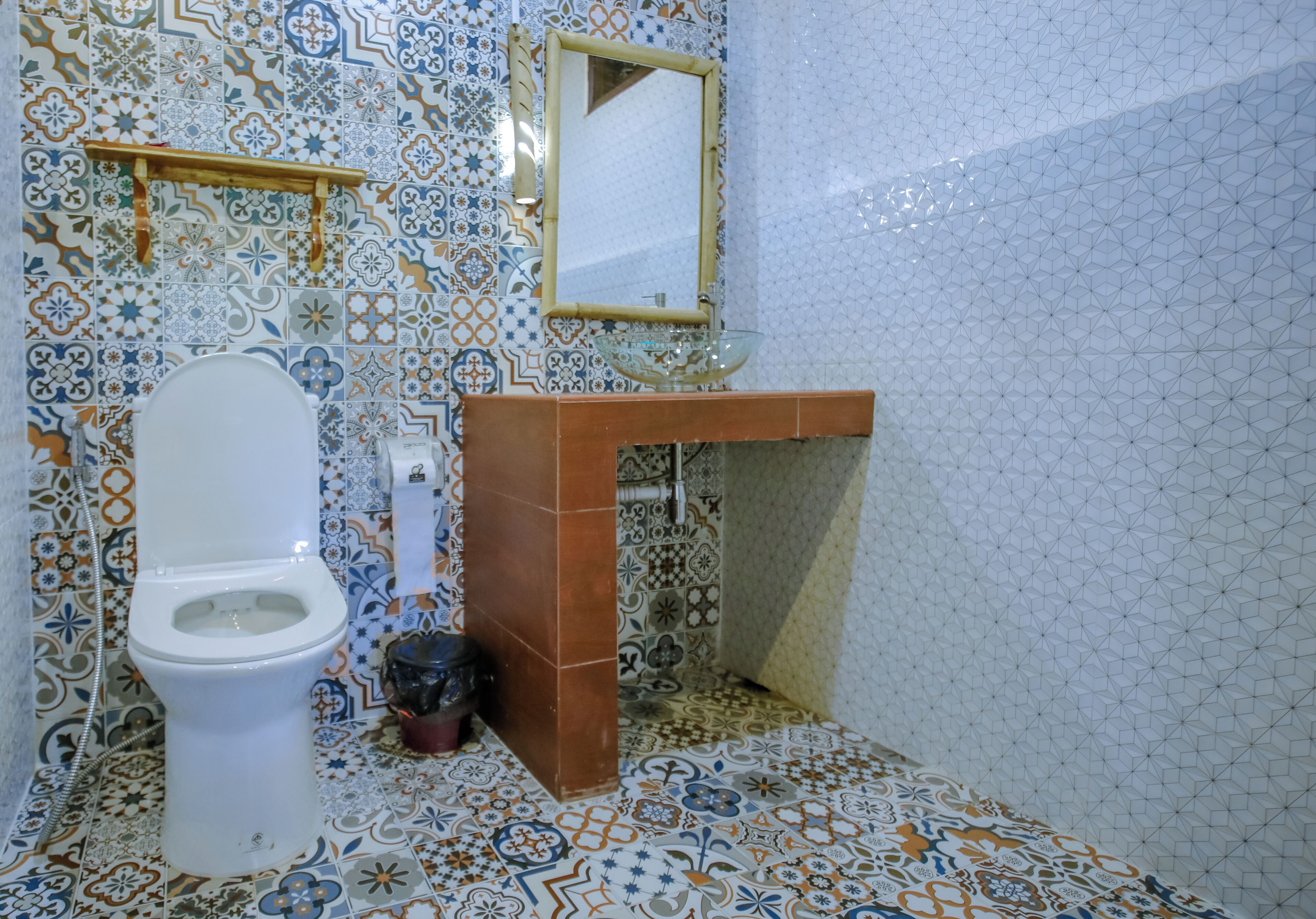 A bathroom with a white toilet, a sink with a glass basin, and a mirror above it.