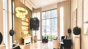 A spacious, modern living room with a large window, a central plant, and a stylish chandelier. - Luxury 1-Bedroom Apartment At Burj Crown. (Dubai)