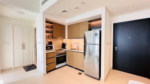A modern kitchen with a stainless steel refrigerator, a built-in oven, and a coffee machine. - Luxury 1-Bedroom Apartment At Burj Crown. (Dubai)