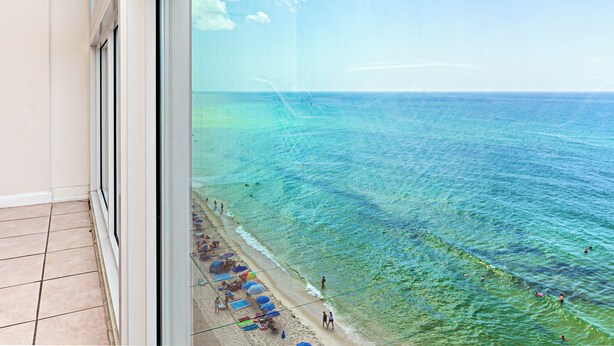 Un balcon avec vue sur une plage et l’océan.