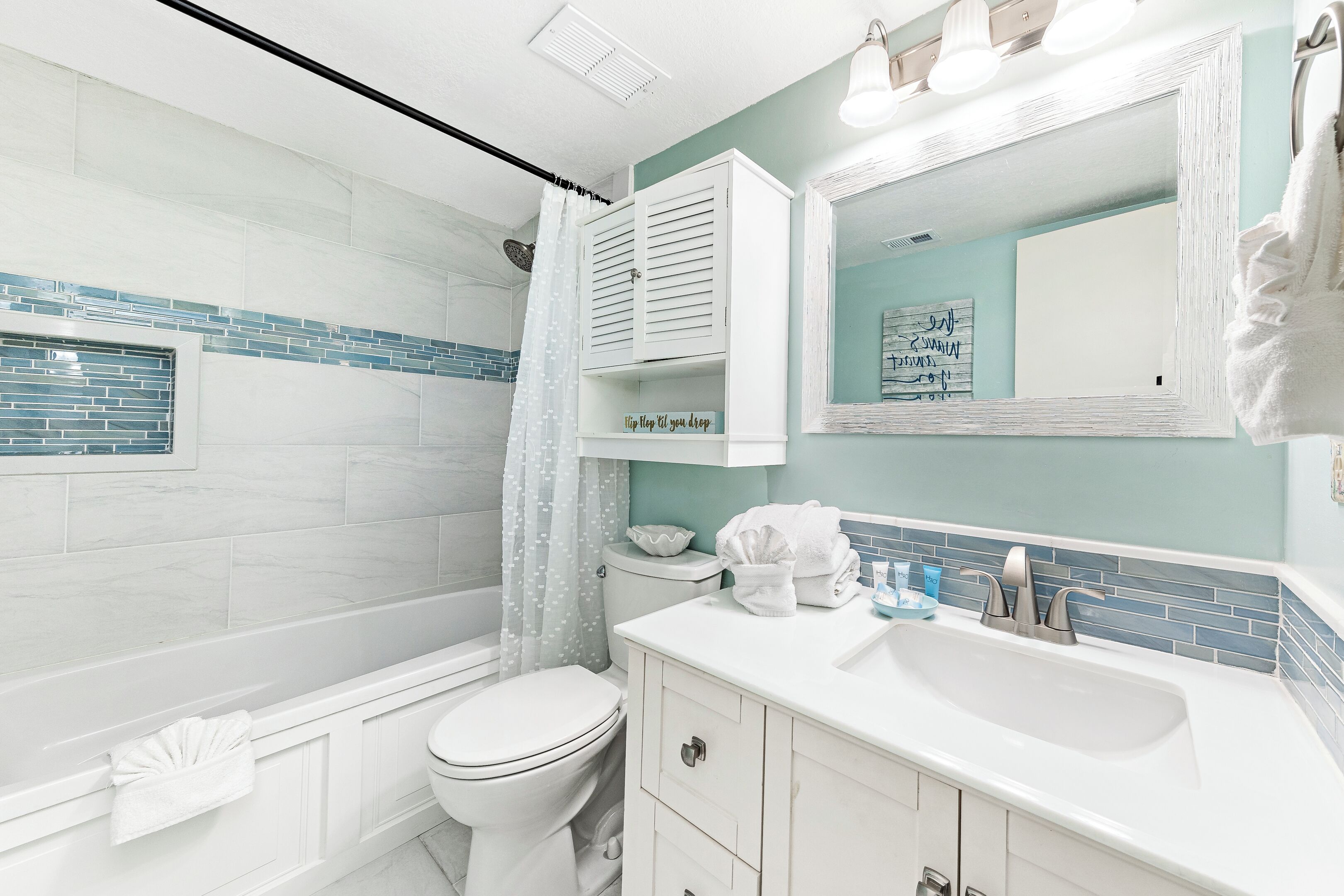 A bathroom with a toilet, sink, and shower.