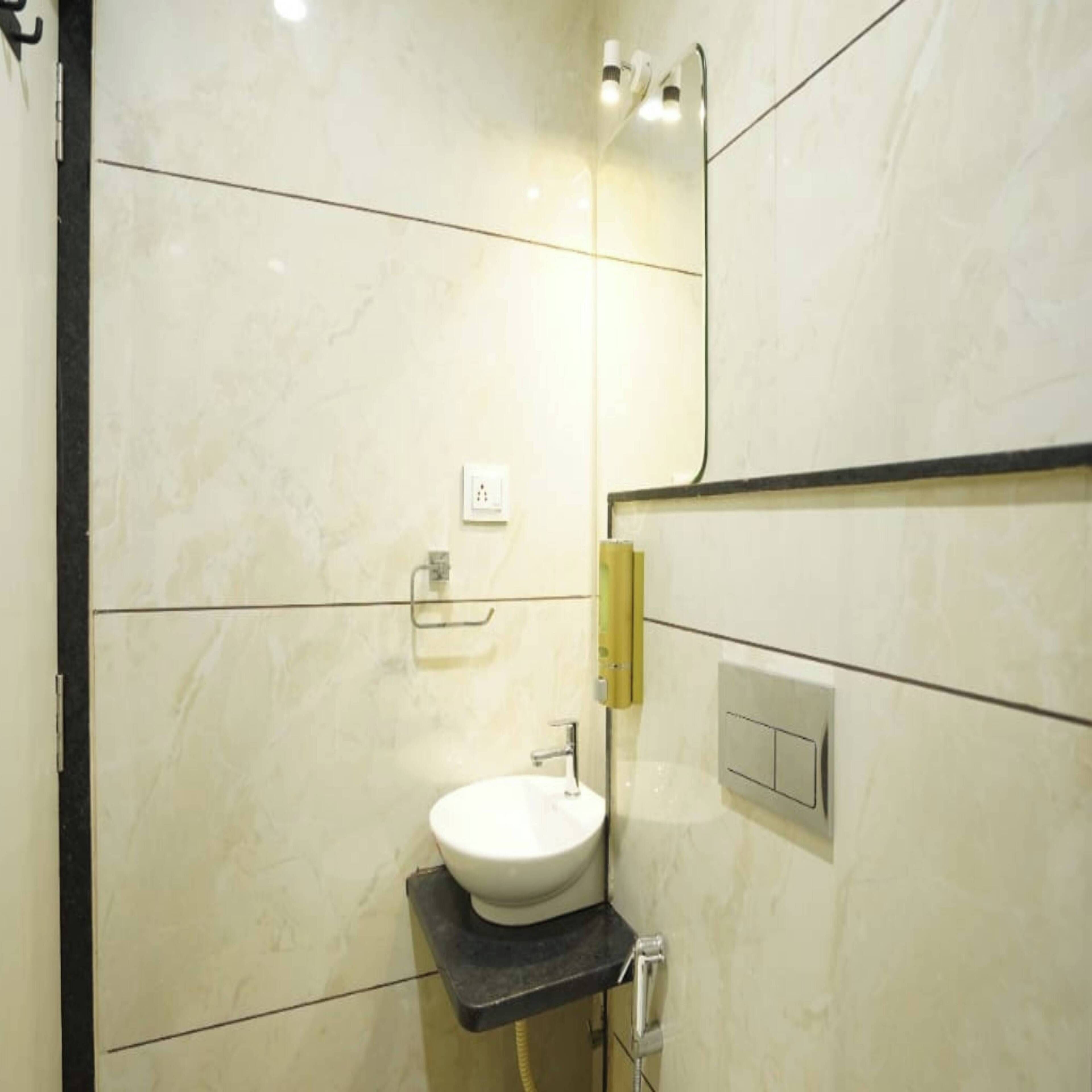 A modern bathroom with a white sink, a mirror, and a towel rack.