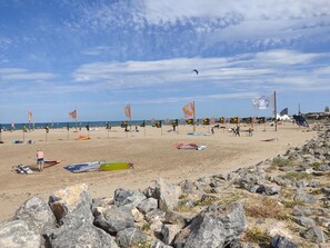 Une plage avec des drapeaux, des rochers et un ciel dégagé.