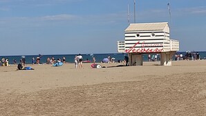 Une plage avec un poste de surveillance pour les sauveteurs, portant l’inscription « Garrison Beach ».