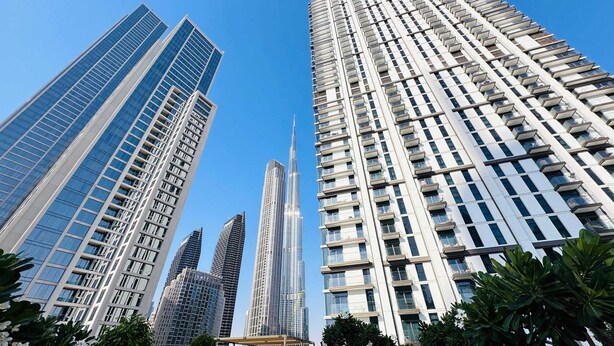 A cluster of high-rise buildings with modern architecture, featuring glass facades and a variety of window patterns.