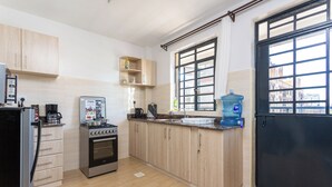 Una cocina con gabinetes de madera, una estufa y un dispensador de agua.