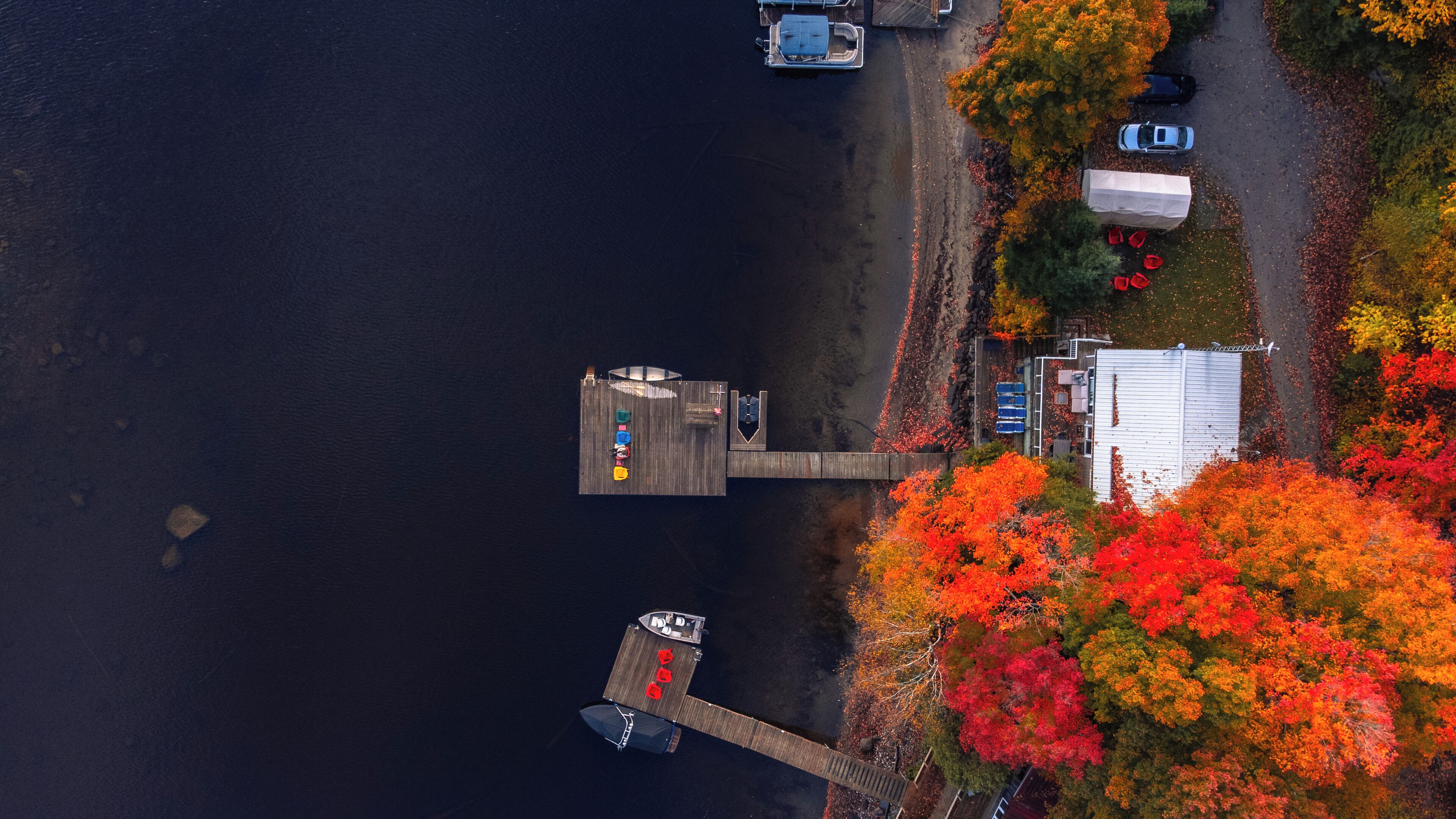 A dock extending into a body of water with a small boat docked at the end.