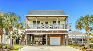 A two-story house with a covered front porch, a garage, and a balcony.