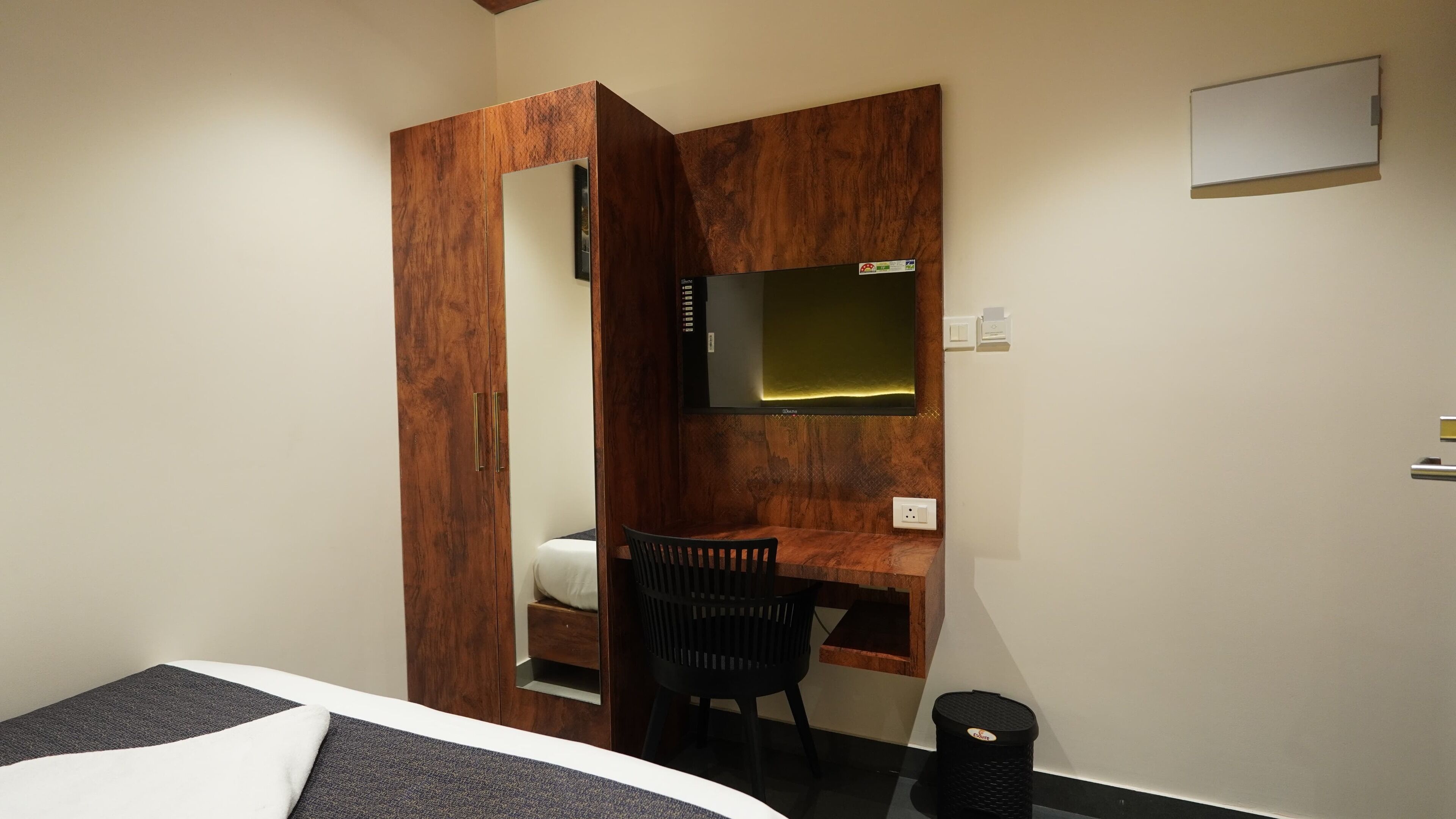 Un dormitorio con un armario de madera, un escritorio, una silla y una cama.