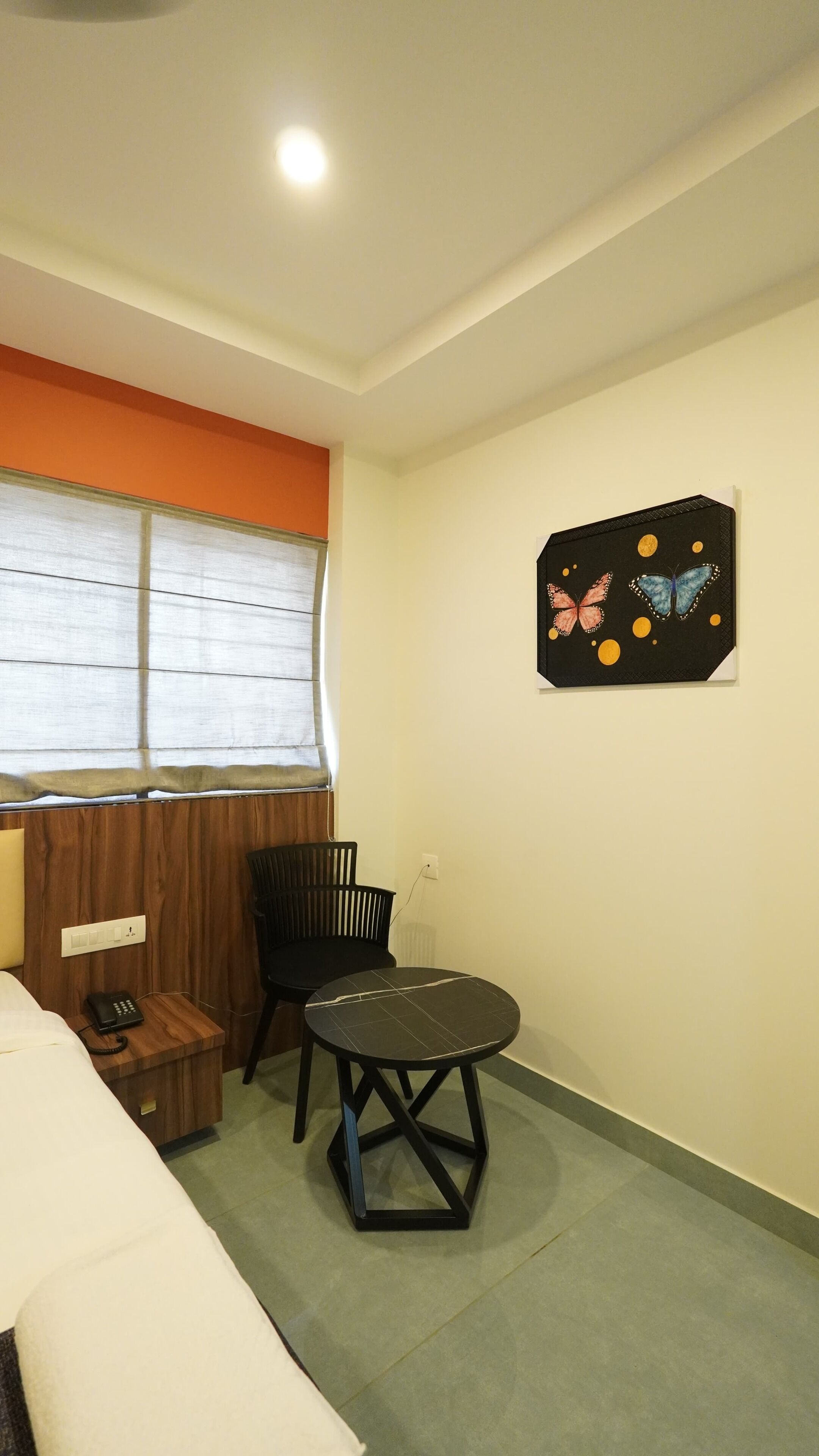 Una habitación pequeña con cama, escritorio, silla y un cuadro en la pared.