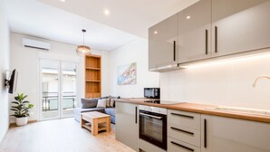 A modern kitchen with a built-in oven, a wooden countertop, and a large window. - Modern 2-bedroom Gem Close to Metro (Athens)