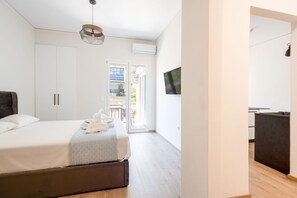 Een slaapkamer met een bed, een kledingkast en een televisie aan de muur.