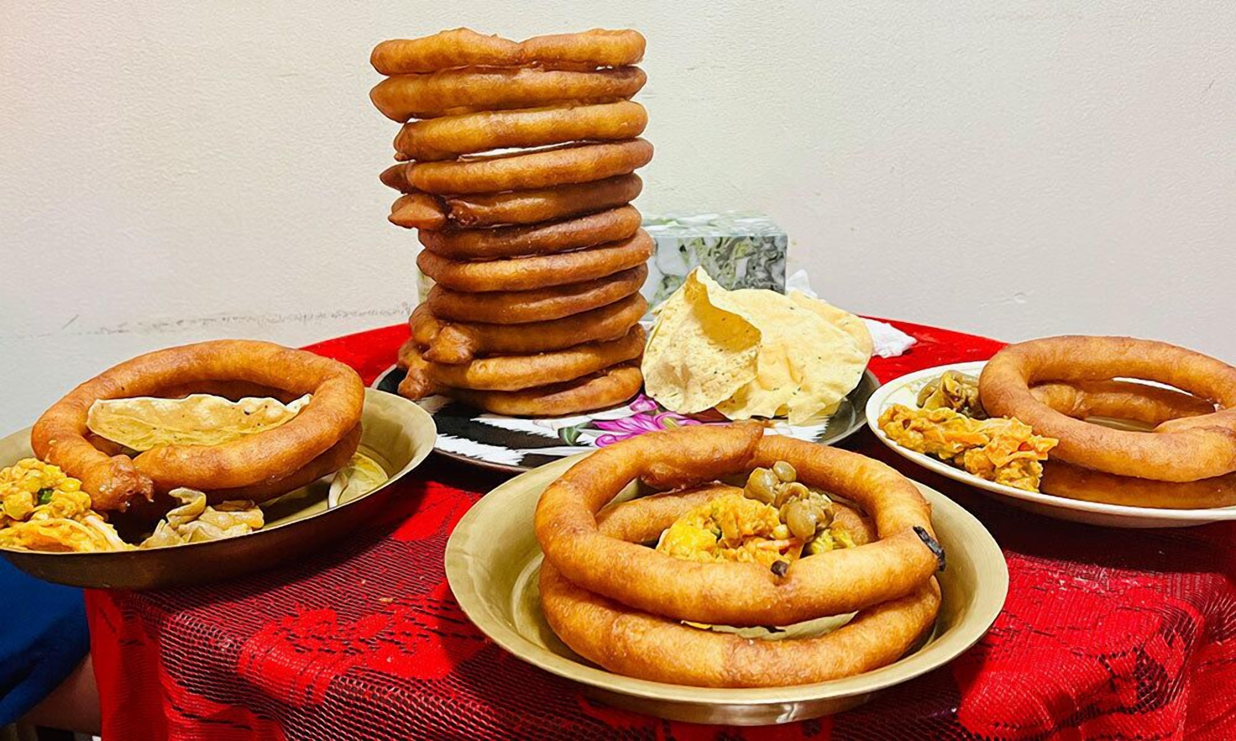 Una mesa con diversas comidas fritas, incluyendo aros apilados y platos con diferentes opciones.