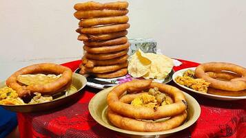 Una mesa con diversas comidas fritas, incluyendo aros apilados y platos con diferentes opciones.