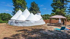 Una escultura de hielo blanca en un jardín con un pabellón y mobiliario exterior.