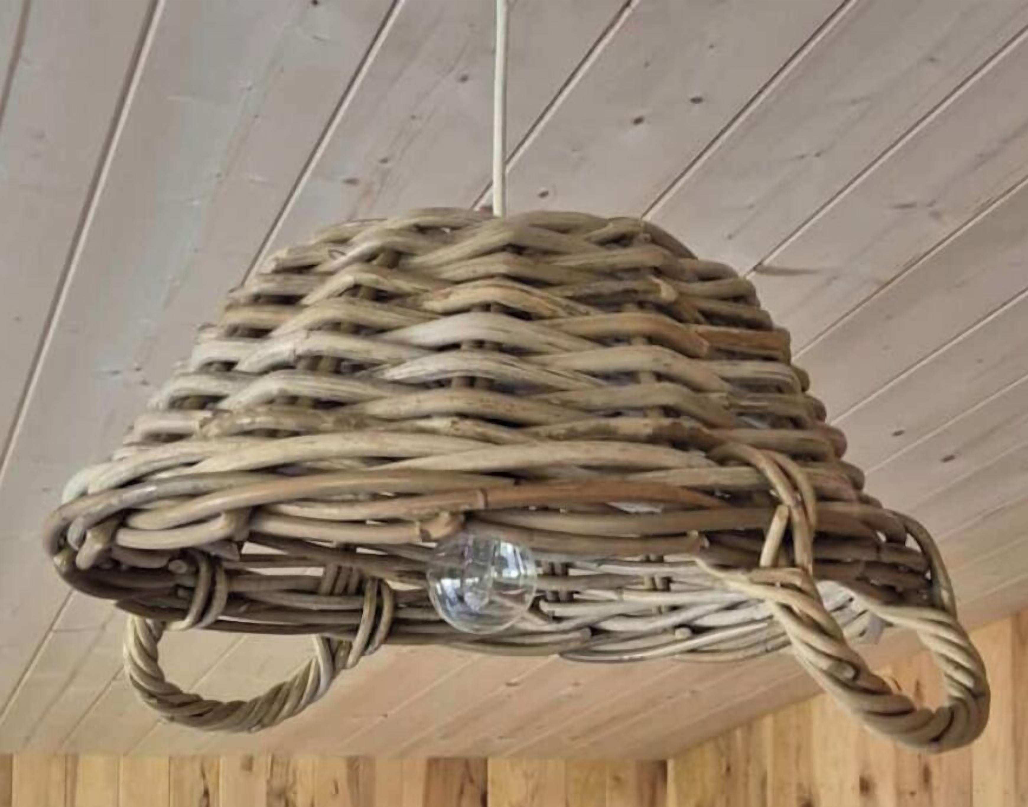 A woven basket with handles hanging from a ceiling.