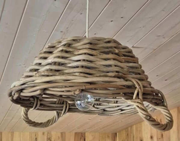 A woven basket with handles hanging from a ceiling.