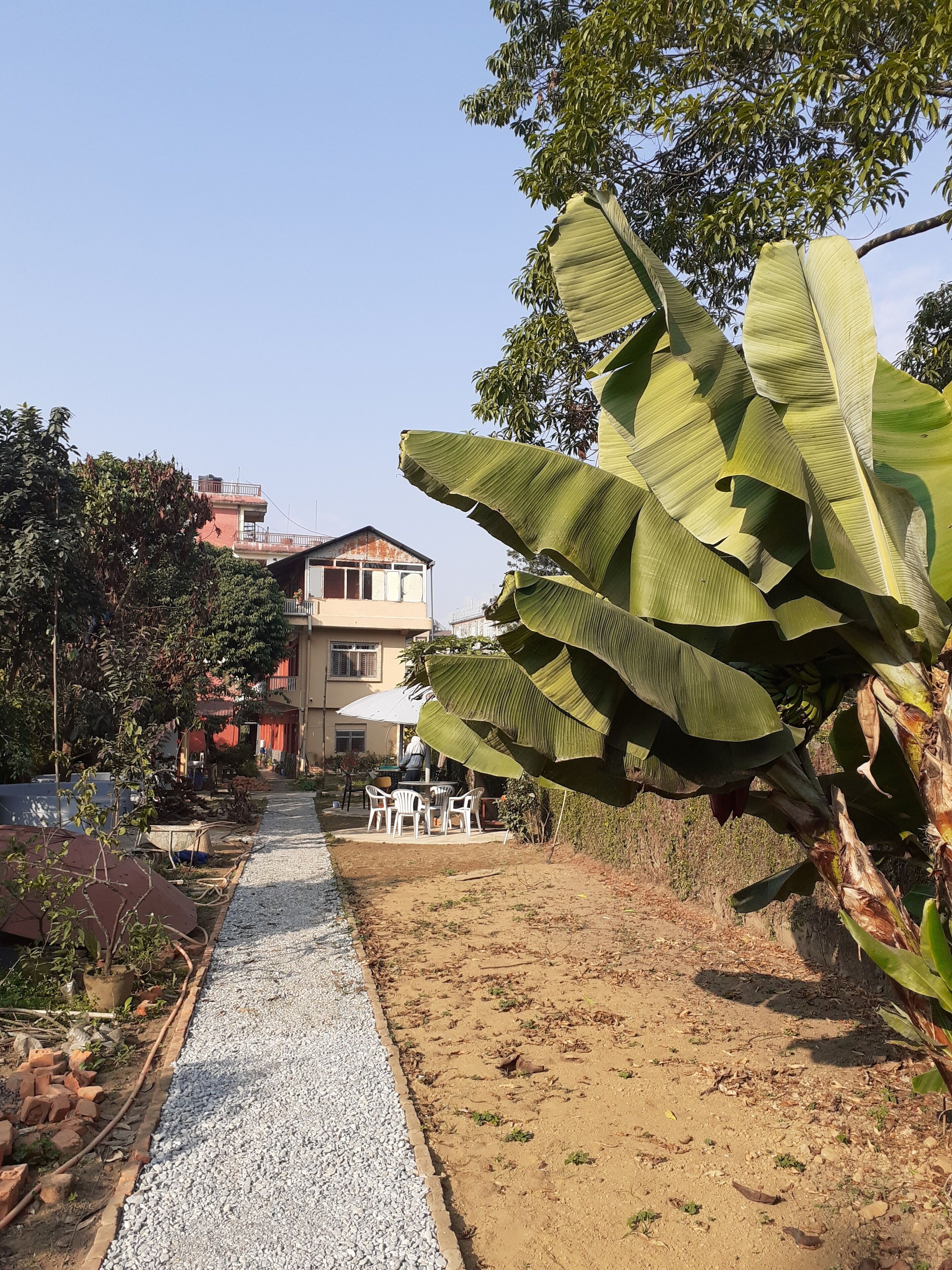 A pathway leading to a two-story building with a balcony.