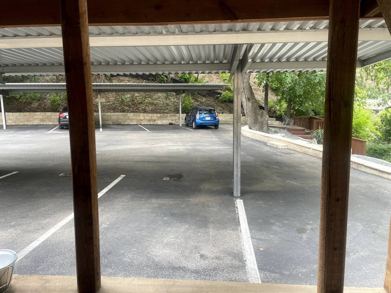 A covered parking area with a car parked in the distance.