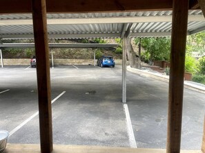 A covered parking area with a car parked in the distance. - Travis Heights Oasis! (Austin)