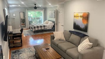 A spacious living room with a sofa, coffee table, and a ceiling fan.