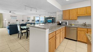 A modern kitchen with granite countertops, wooden cabinets, and a dishwasher.
