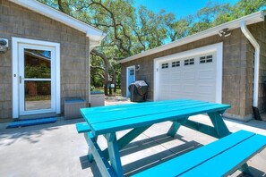 Un garage con una porta bianca e una zona esterna coperta.