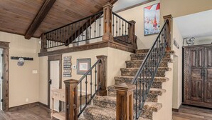 Een trap met houten leuningen en een kamerbreed tapijt.
