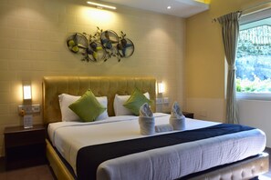 Une chambre d’hôtel avec un grand lit, deux tables de chevet, une œuvre d’art accrochée au mur et une fenêtre avec des rideaux.