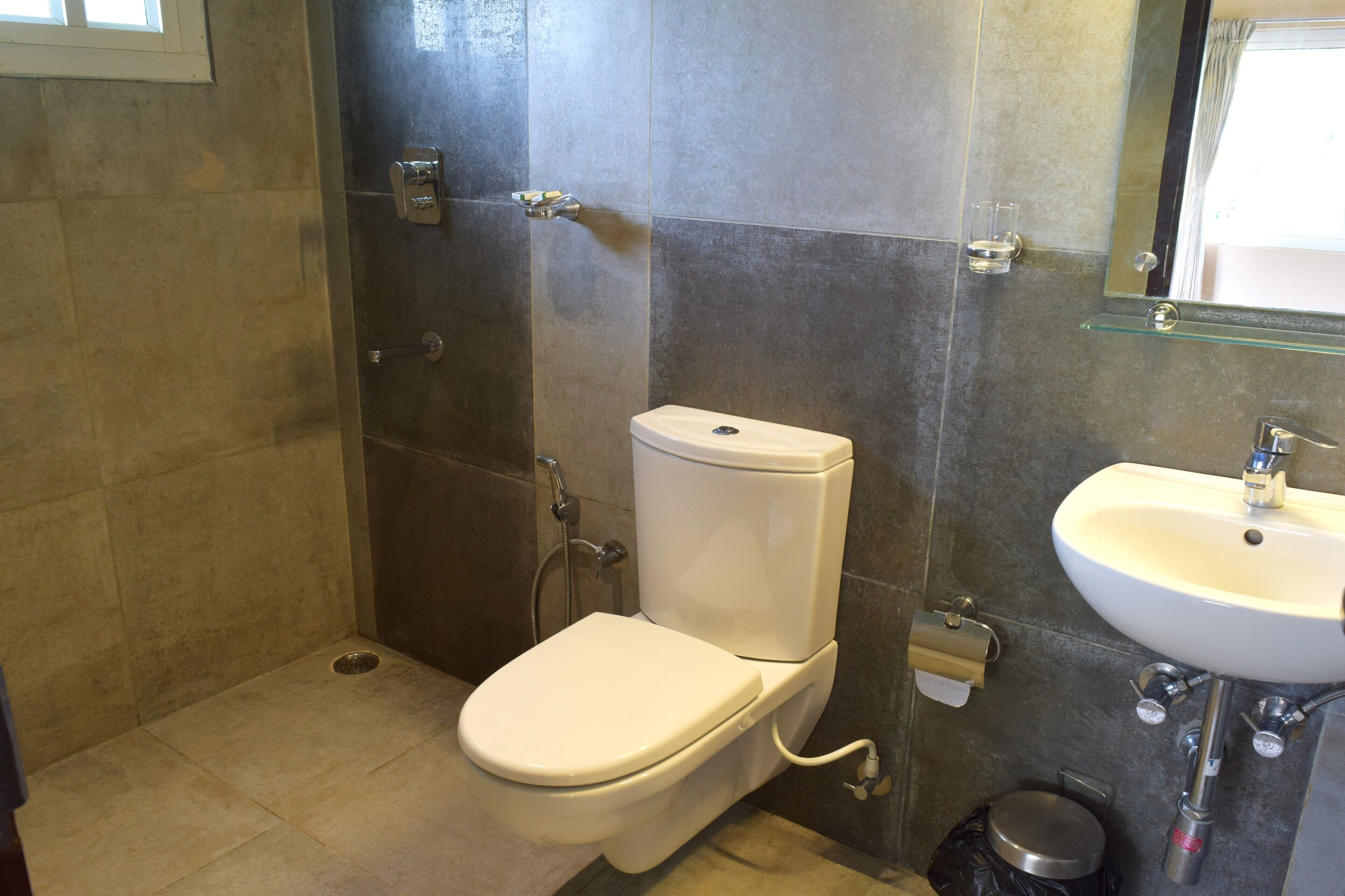 A bathroom with a toilet, shower, and sink.