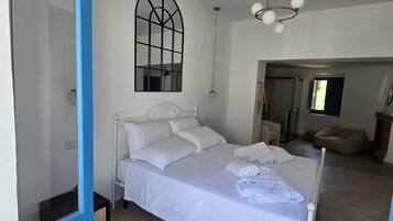 Une chambre à coucher comprenant un lit, une table de chevet, un miroir et un luminaire au plafond.