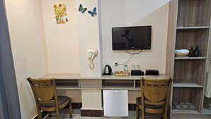 A compact living space with a kitchenette, a TV mounted on the wall, and a small refrigerator. - Thon Thean Hotel  (Phnom Penh)