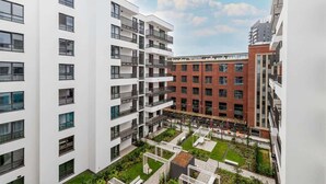 A modern apartment complex with multiple floors, balconies, and a courtyard with greenery. - Modern Apartment | Parking, Balcony and Workspace (Gdansk)
