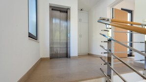 A modern interior with a staircase, elevator, and a door leading to another room. - Deluxe apartment Noeli (Krvavica)