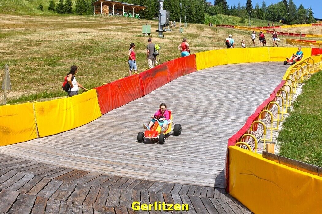A go-kart track with a wooden boardwalk and safety barriers.
