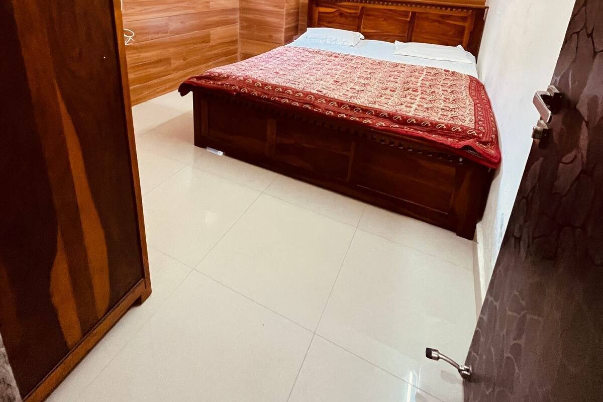 A bedroom with a wooden bed, a wooden wardrobe, and a ceiling fan.