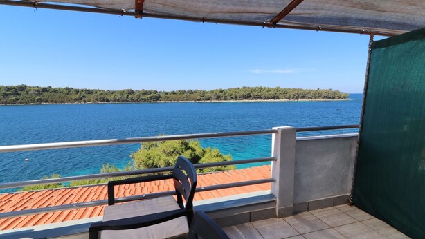 Un balcone con vista su un lago e una foresta.