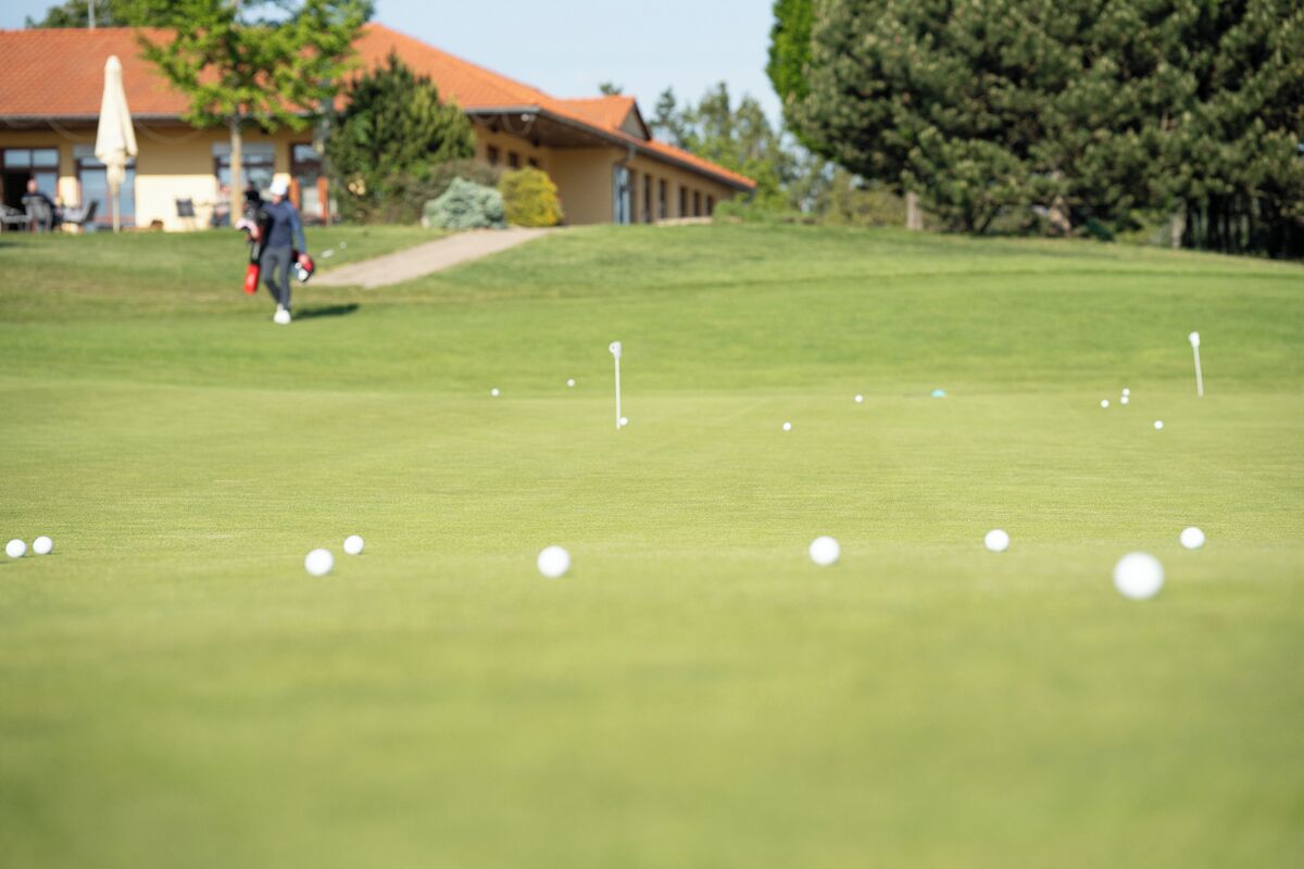 Um campo de golfe com um edifício ao fundo.