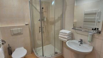Ein modernes Badezimmer mit einer Duschkabine, einer Toilette und einem Waschbecken.