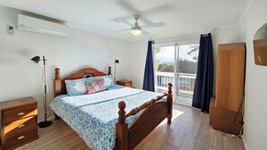 A bedroom with a wooden bed, a ceiling fan, a nightstand, a dresser, and a view of the outdoors through a sliding glass door. - 300 Steps - 300 Steps to Robes' famous Longbeach - Pet friendly Inside (Robe)