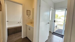 A bathroom with a bathtub, sink, and toilet. There is a framed certificate on the wall. - 300 Steps - 300 Steps to Robes' famous Longbeach - Pet friendly Inside (Robe)