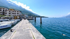 A dock with boats, a mountain in the background, and a clear sky.