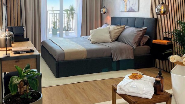A modern hotel room with a bed, desk, and a view of the outdoors. - Superb BnB with private Jacuzzi & Bathtub + Breakfast Included (Hvar)