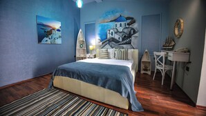 Un dormitorio con cama, mesita de noche, lámpara, modelo de barco y un cuadro en la pared.